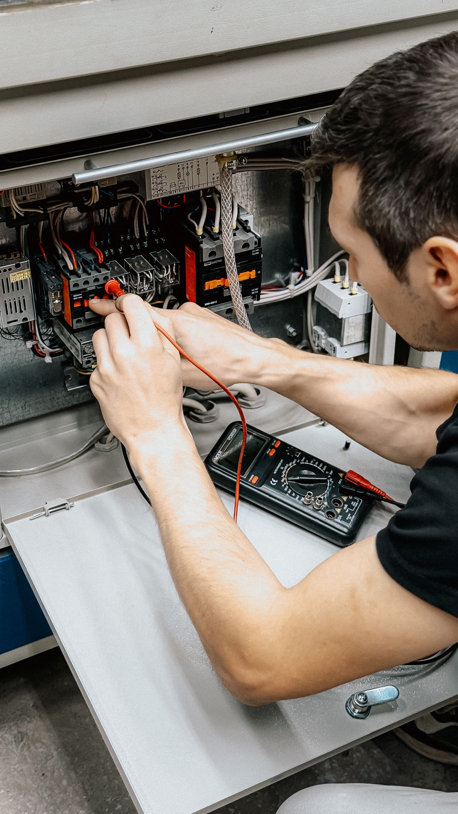 Electrician diagnosing electrical equipment with a multimeter